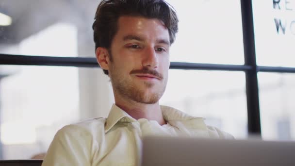 ラップトップコンピュータ ローアングル 頭と肩で作業する若い白人男性 — ストック動画