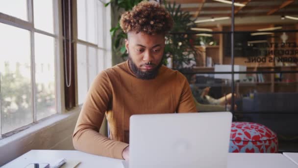 Millennial Bloguero Negro Usando Portátil Escritorio Junto Ventana Una Oficina — Vídeo de stock