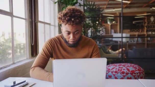 Millennial Bloguero Negro Usando Portátil Teléfono Inteligente Escritorio Una Oficina — Vídeos de Stock