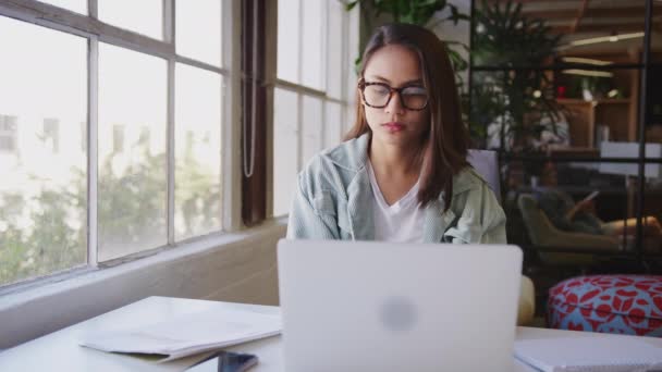カジュアルなオフィスでラップトップで作業する机に座って ミレニアルアジアの女性のクリエイティブ クローズアップ — ストック動画