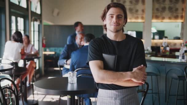 Camarero Masculino Sonriendo Cámara Con Los Clientes Segundo Plano Filmado — Vídeos de Stock