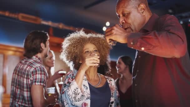 シニアカップルは一緒にバーでショットを飲み 一緒に踊る スローモーションで撮影 — ストック動画