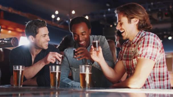 一緒にバーでショットを飲む男性の友人のグループ スローモーションで撮影 — ストック動画