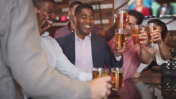バーでビールを飲んで乾杯する友人のグループ スローモーションで撮影 — ストック動画