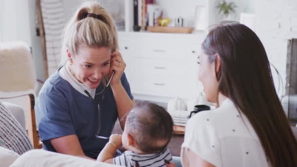 Kvinnlig Sjukvårdspersonal Besöker Unga Mamma Och Hennes Nyfödda Son Hemma — Stockvideo