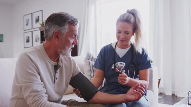 Женщина Медицинский Работник Измеряет Кровяное Давление Пожилого Человека Время Посещения — стоковое видео
