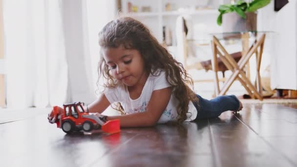Jonge Hispanic Meisje Liggend Vloer Zitkamer Spelen Met Toy Digger — Stockvideo