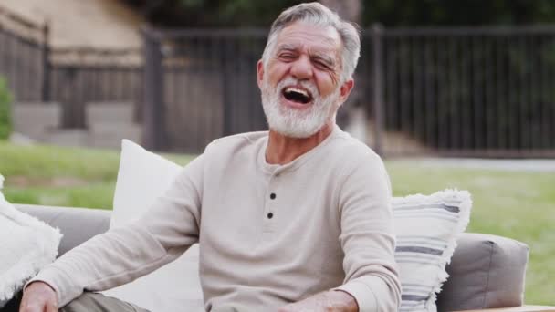 Älterer Hispanischer Mann Sitzt Auf Einem Sofa Garten Und Lacht — Stockvideo