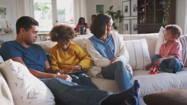 Eltern Und Ihre Beiden Kinder Sitzen Zusammen Auf Dem Sofa — Stockvideo