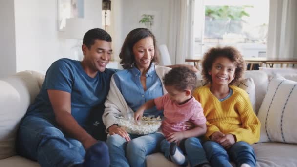 年轻的家庭坐在客厅的房间里 看电视和吃爆米花 — 图库视频影像