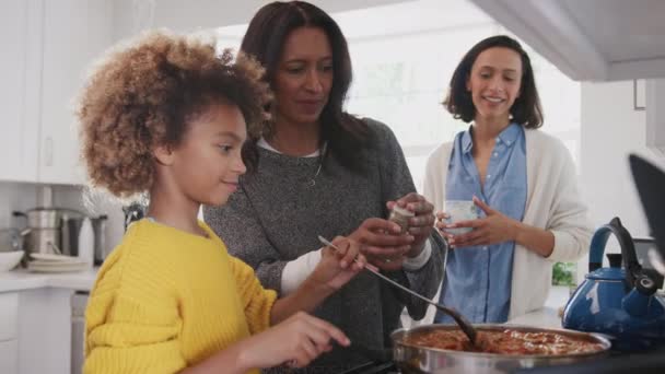 前十代のアフリカ系アメリカ人の女の子は 彼女の祖母と母と台所で食べ物を調理し クローズアップ — ストック動画