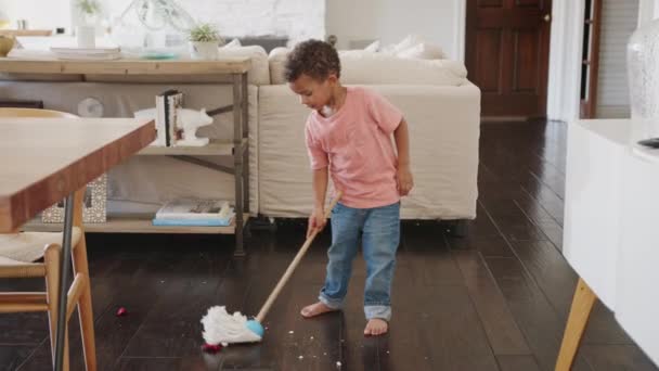 モップでダイニングルームの床を掃除する3歳のアフリカ系アメリカ人の男の子 フルレングス — ストック動画