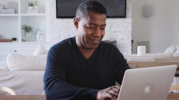 Middelbare Leeftijd Afro Amerikaanse Man Zittend Aan Een Tafel Met — Stockvideo