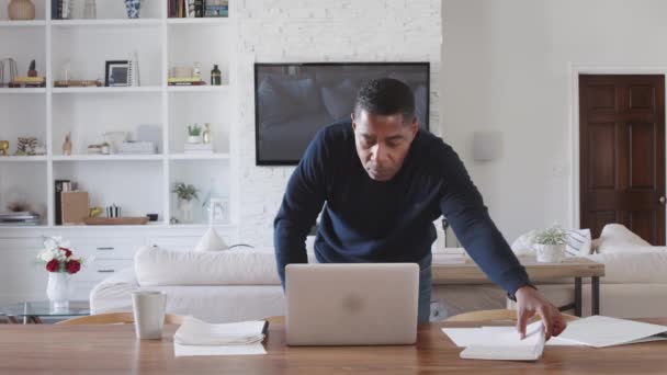 食堂のテーブルに立って書類を見て ラップトップコンピュータを使用している中年の男性 — ストック動画