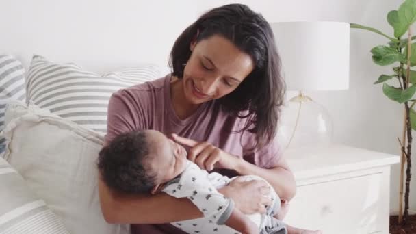 千禧年的母亲坐在床上抱着她熟睡的婴儿 — 图库视频影像