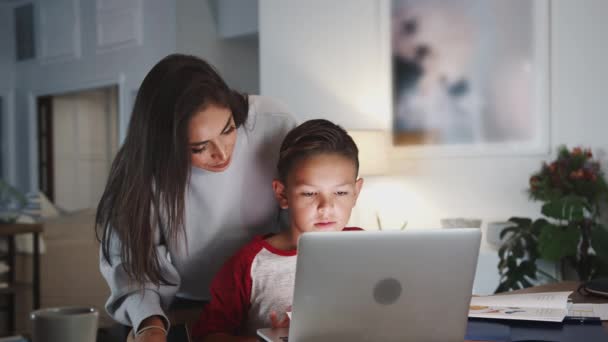노트북 컴퓨터와 숙제를하는 그녀의 아들을 히스패닉 측면보기 — 비디오