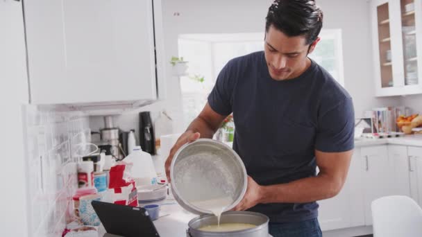 Millennial Hombre Vertiendo Mezcla Pastel Una Forma Siguiendo Una Receta — Vídeo de stock