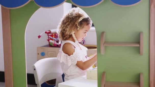 幼児学校のプレイハウスで店を再生する若い混合レース女子高生 バックライト — ストック動画