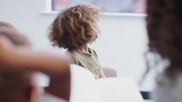 Ung Blandad Ras Skolpojke Sitter Med Klasskamrater Infant School Gör — Stockvideo