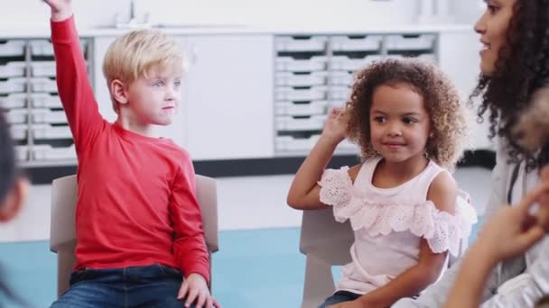 Infant School Children Raising Hands Speak Lesson Female Teacher Close — Stock Video