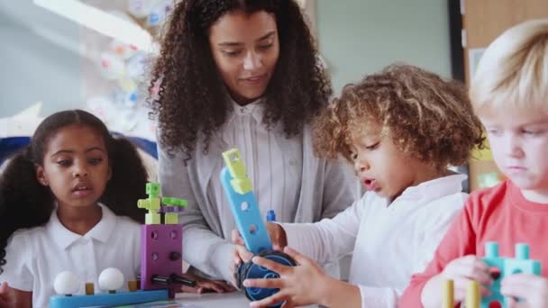 Vrouwelijke Baby School Leraar Tafel Met Drie Kinderen Met Behulp — Stockvideo