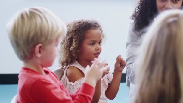 教室で幼児が手を挙げ 女子教師と数える学習 サイドビュー — ストック動画