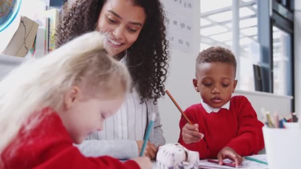 Sonriente Maestra Escuela Infantil Sentada Una Mesa Con Niños Dibujando — Vídeos de Stock