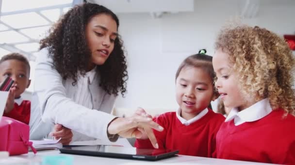 Вчителька Дитячої Школи Яка Допомагає Двом Дівчатам Використовувати Планшетний Комп — стокове відео