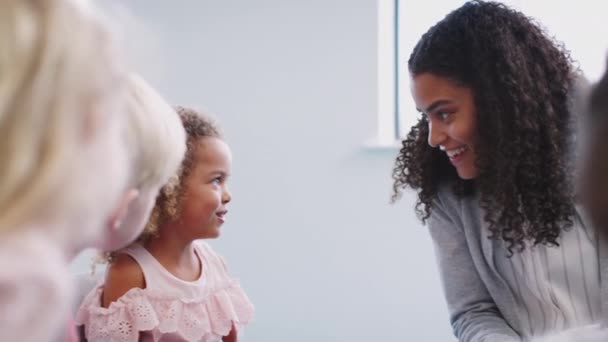 Insegnante Scuola Materna Femminile Seduta Classe Parlare Con Bambini Vicino — Video Stock