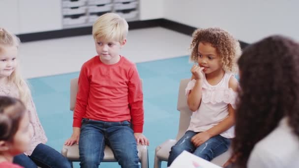 Niños Escuela Infantil Sentados Sillas Aula Escuchando Lectura Maestro Vista — Vídeos de Stock