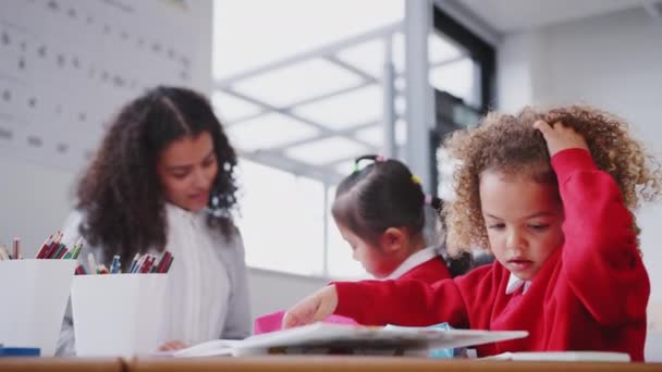 Ungskolflicka Klädd Uniform Arbetar Vid Ett Skrivbord Ett Spädbarn Skolklass — Stockvideo