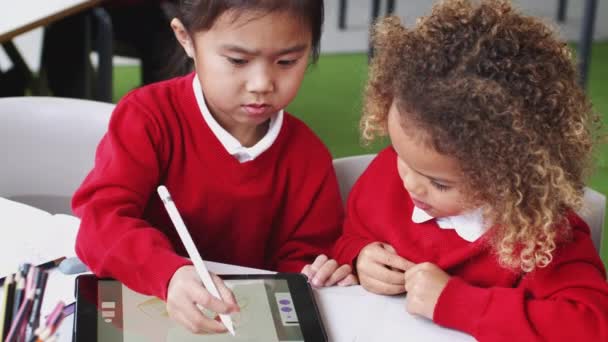 タブレットコンピュータを使用して幼児学校の教室で描く若い混合レース女子高生 クローズアップ — ストック動画