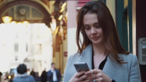 年轻的白人女商人站在繁忙的伦敦街道上使用她的智能手机 选择性的焦点 — 图库视频影像