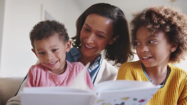 Madre Afroamericana Sentada Sofá Leyendo Sus Dos Hijos Ángulo Bajo — Vídeos de Stock