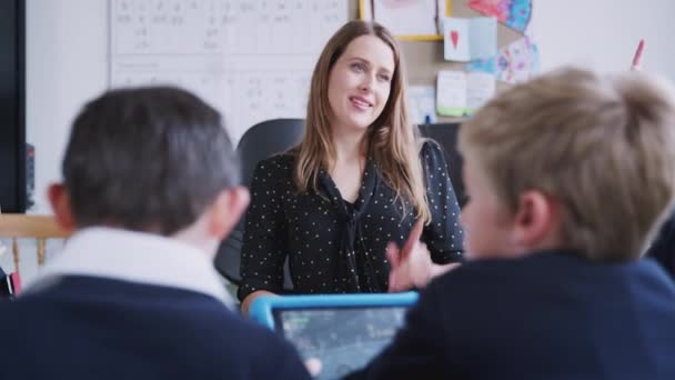 Lehrerin Sitzt Einer Grundschulstunde Einem Tisch Und Spricht Mit Schülern — Stockvideo