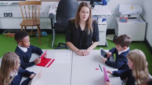 Tablet Bilgisayar Kullanan Okul Çocukları Ile Bir Masada Kadın Ilköğretim — Stok video