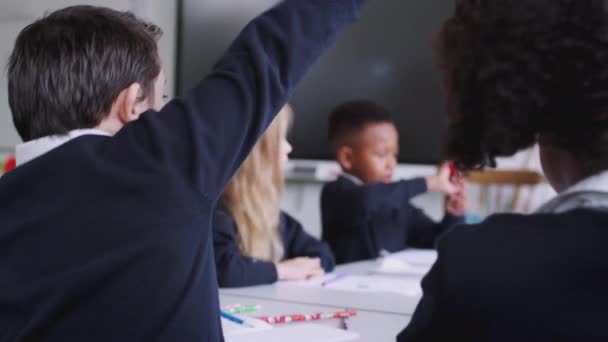 Grundschulkinder Schreibtisch Einem Klassenzimmer Heben Die Hände Eine Frage Beantworten — Stockvideo