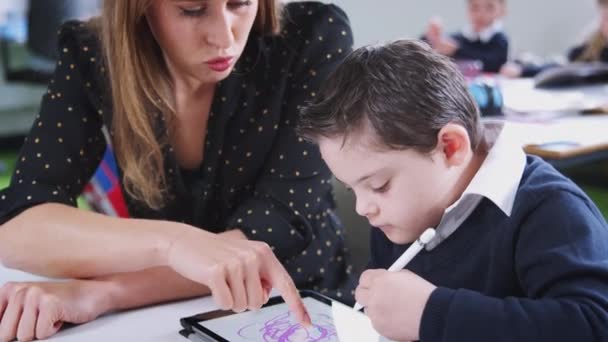 Bir Ilköğretim Sınıfında Tablet Kullanan Sendromlu Bir Çocukla Çalışan Kadın — Stok video