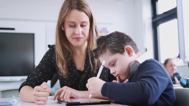 Kvinnlig Lärare Som Arbetar Med Syndrom Pojke Med Hjälp Tablett — Stockvideo