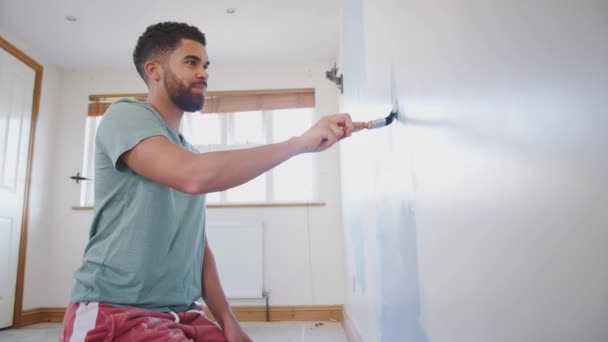 Jonge Man Versieren Kamer Nieuwe Huis Schilderij Muur Met Borstel — Stockvideo