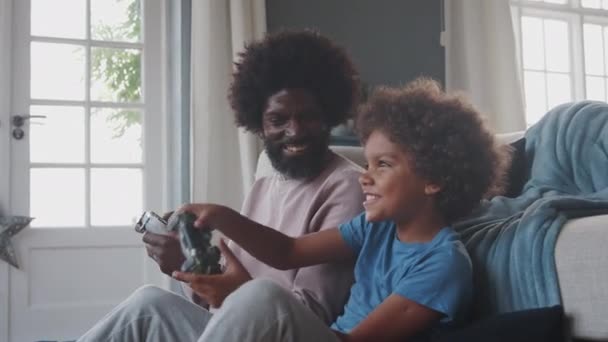중년의 아버지와 아들이 비디오 게임을하는 거실에서 바닥에 — 비디오