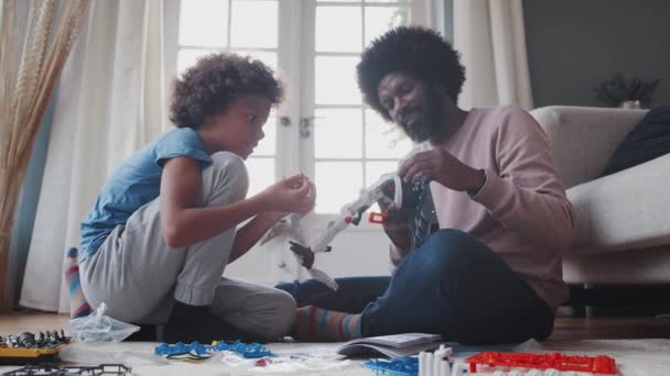 Ayah Duduk Lantai Rumah Membantu Anak Pra Remaja Membangun Mainan — Stok Video