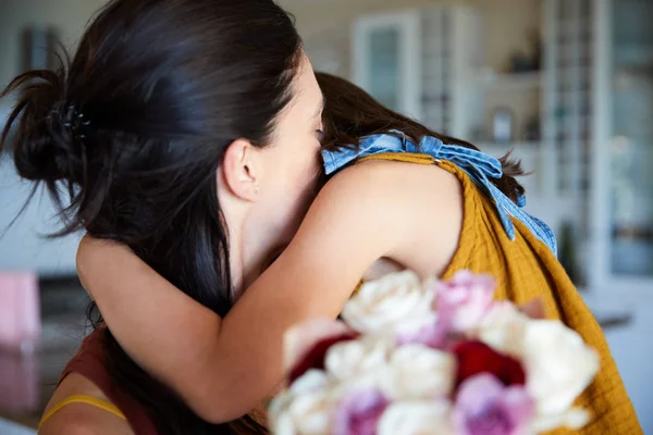 彼女の誕生日に贈り物として彼女の花を与えた後 彼女の母親を抱きしめる若い白人の女の子は クローズアップ — ストック写真