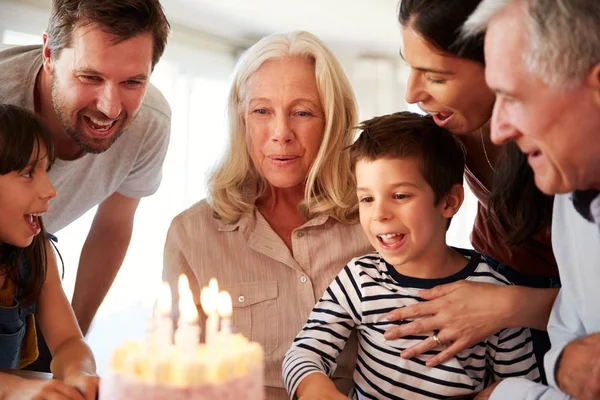 家族と一緒に彼女の誕生日を祝うシニア白人女性は 彼女のケーキにろうそくを吹き消し クローズアップ — ストック写真