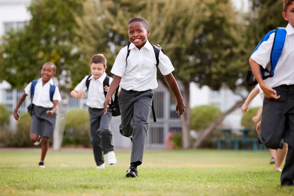 Emocionados Alumnos Escuela Primaria Que Llevan Uniforme Corriendo Través Del — Foto de Stock