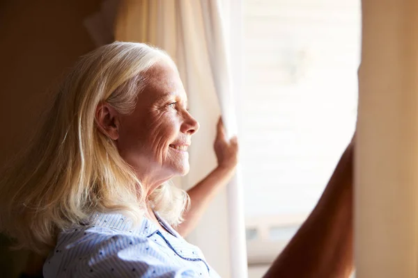 Glimlachend Senior Blanke Vrouw Het Openen Van Gordijnen Een Zonnige — Stockfoto