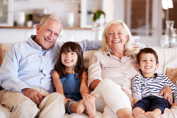 Blanca Pareja Ancianos Sus Nietos Sentados Sofá Juntos Casa Sonriendo — Foto de Stock