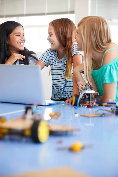 放課後のコンピュータコーディング教室でロボット車両を構築し プログラムする3人の女子学生 — ストック写真