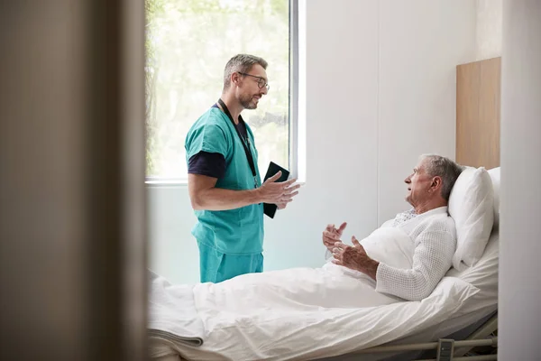 Cirurgião Com Tablet Digital Visitando Paciente Masculino Sênior Cama Hospital — Fotografia de Stock