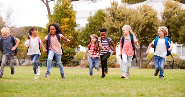 시간에 필드를 달리는 초등학교 학생들 — 스톡 사진